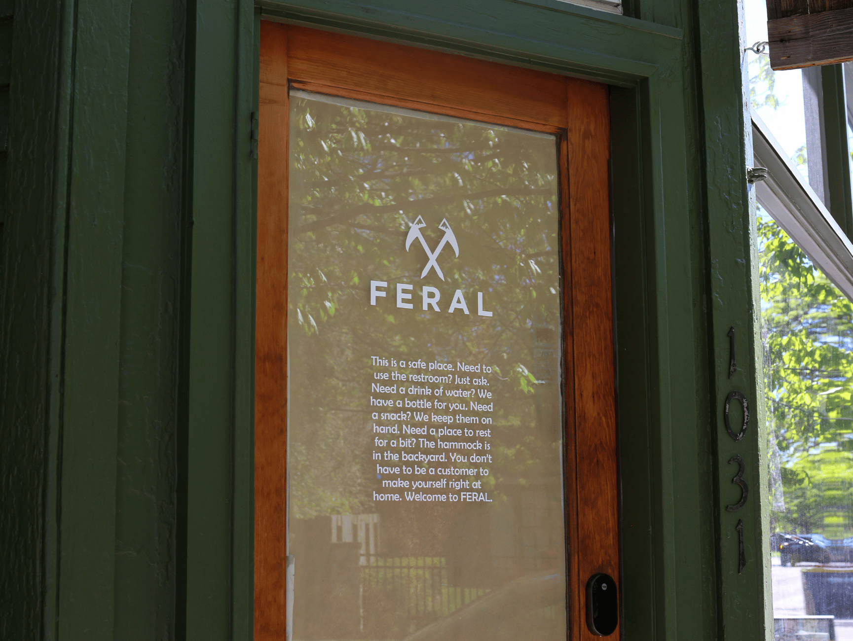 A window at FERAL with a sign, "This is a safe place," offering free amenities.