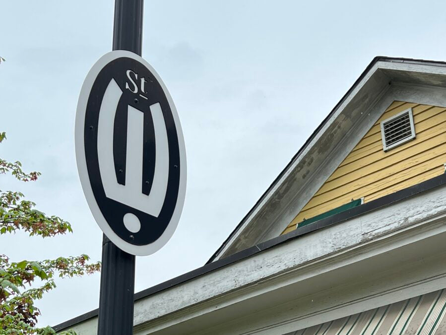 A striking street sign in Grand Rapids, featuring a unique black and white oval design, hinting at the city's creative spirit.
