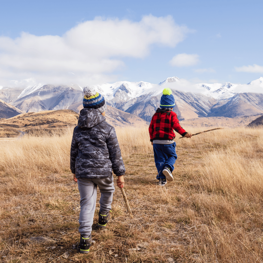 Two kids in warm clothes explore a mountain trail, suggesting an adventurous, outdoor-themed kids collection.