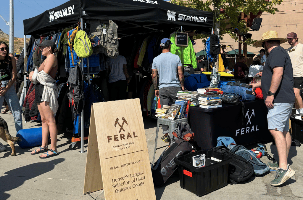 Outdoor gear vendor booth with 'Stanley' and 'Feral' branding at a market.