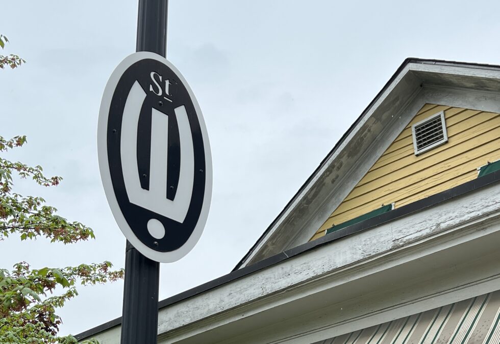A striking street sign in Grand Rapids, featuring a unique black and white oval design, hinting at the city's creative spirit.
