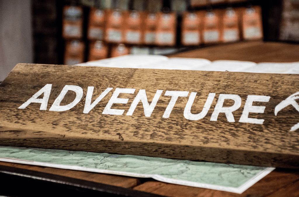 A rustic wooden sign with "Adventure" painted in white evokes a spirit of exploration and resilience.