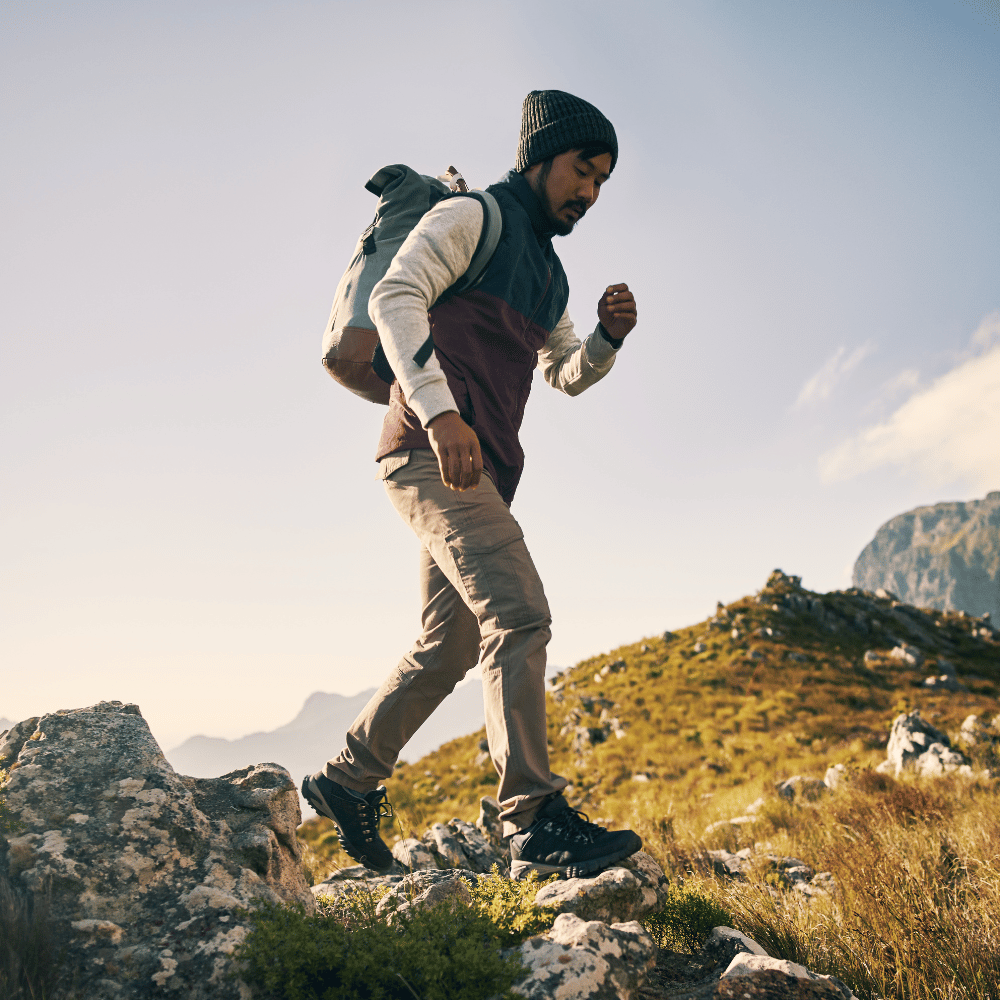 Man hiking on a mountain trail with a backpack