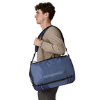Blue duffel bag by Patagonia, with a textured surface and worn over the shoulder.