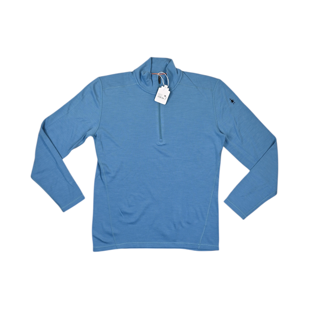 Heathered blue quarter-zip baselayer by Smartwool, laid flat with hangtag attached.