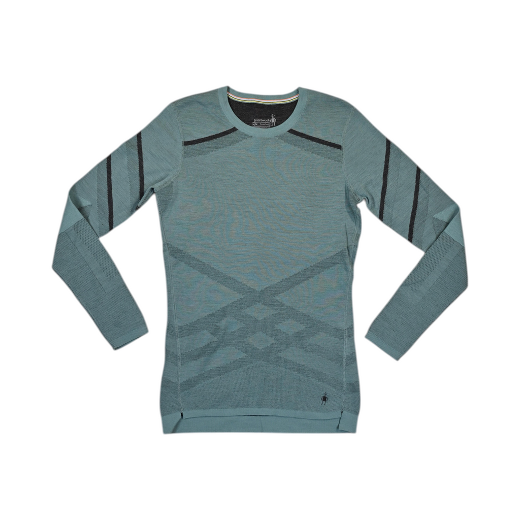 Teal Smartwool crew top laid flat, showing dark diagonal stripe accents.