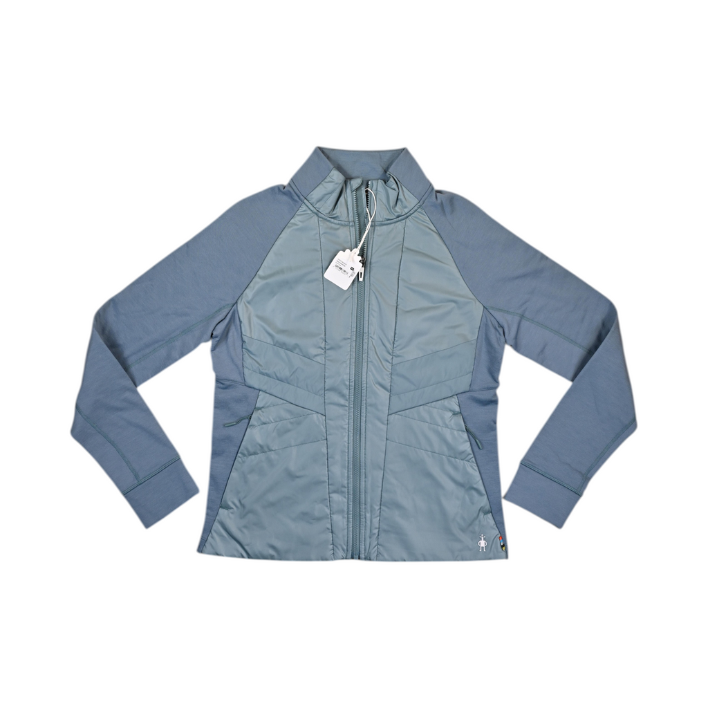 Slate blue Smartwool hybrid jacket laid flat, showing the quilted front panel and fleece sleeves.
