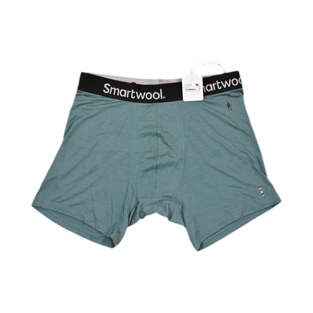 Teal Smartwool boxer brief laid flat, showing the elastic waistband and front seam.