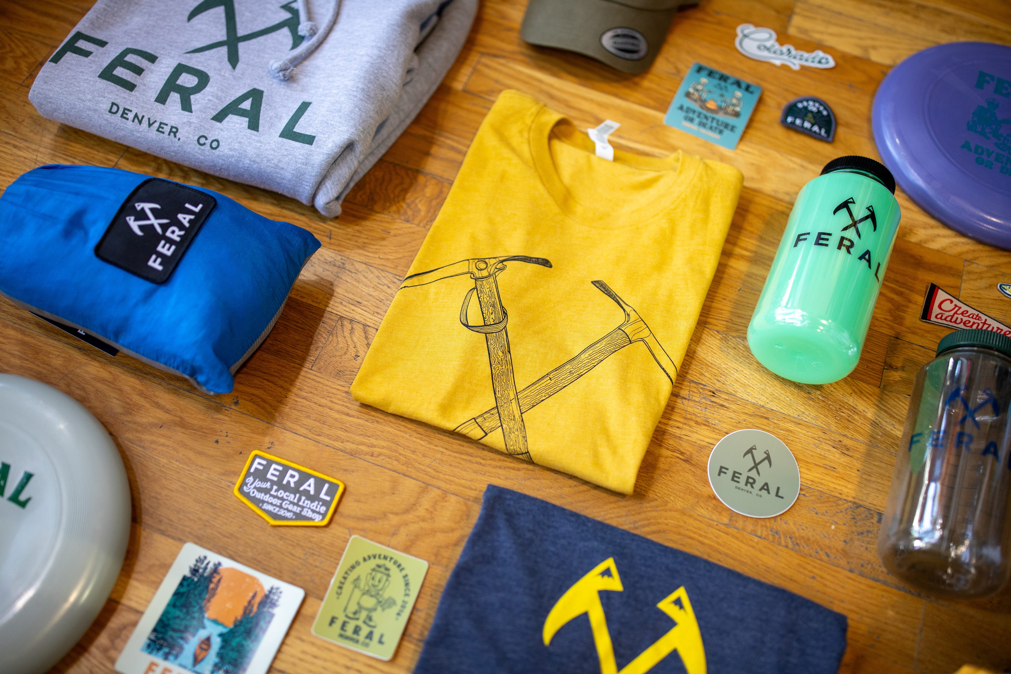 Collection of Feral brand merchandise including t-shirt, hoodie and water bottle.