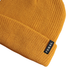 Golden knit beanie by FERAL, displaying ribbed texture and a folded brim with a branded tag on the left.