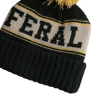 Dark green knit beanie by FERAL with a gray stripe containing the word "FERAL" in dark green letters, topped with a yellow pompom.