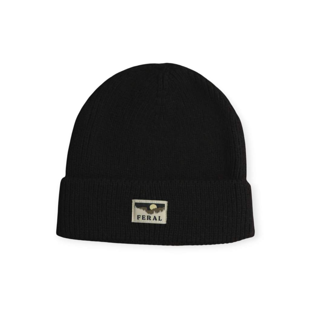 Black knit beanie by FERAL with a rectangular "FERAL" logo patch at the front.