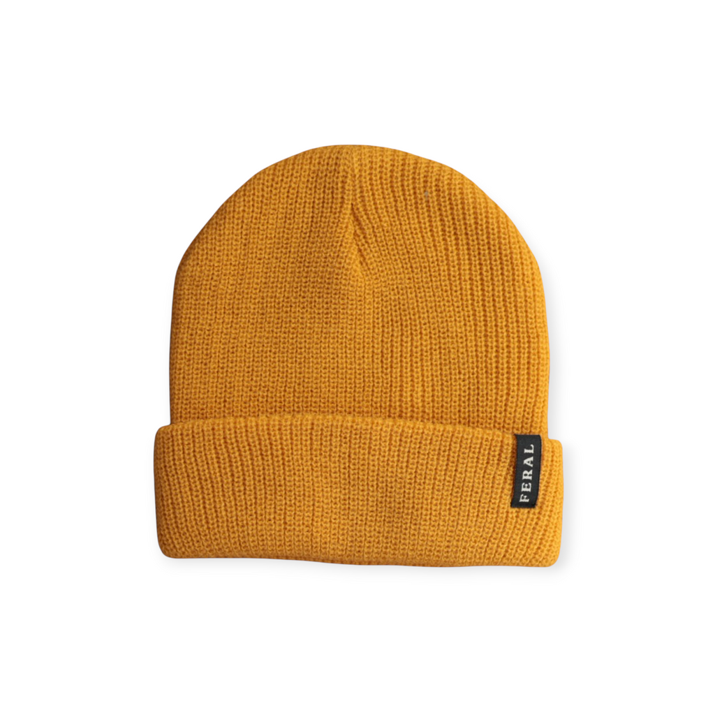 Gold knit beanie by FERAL with a ribbed texture and a folded brim.