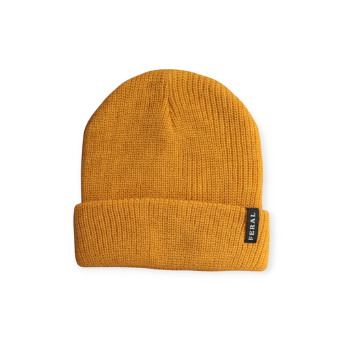 Gold knit beanie by FERAL with a ribbed texture and a folded brim.