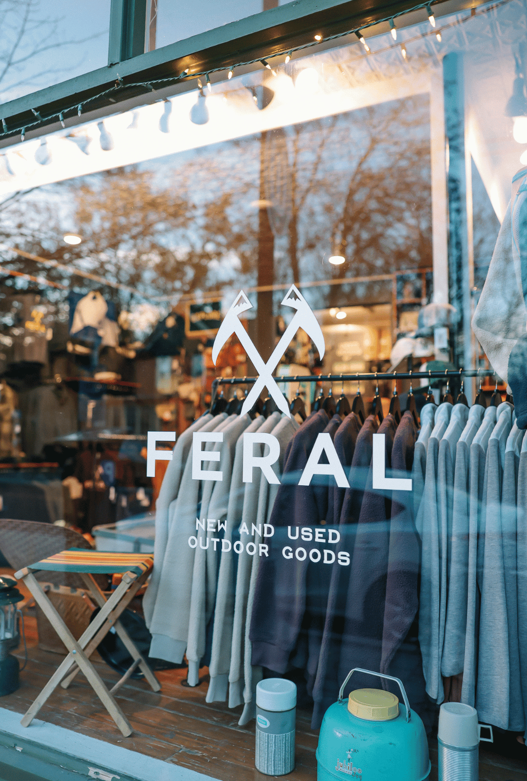 Storefront with 'Feral' outdoor goods display, featuring clothing and equipment.