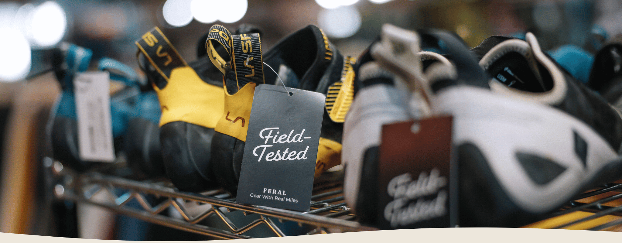 Climbing shoes on a rack with 'Field Tested' labels in a store setting