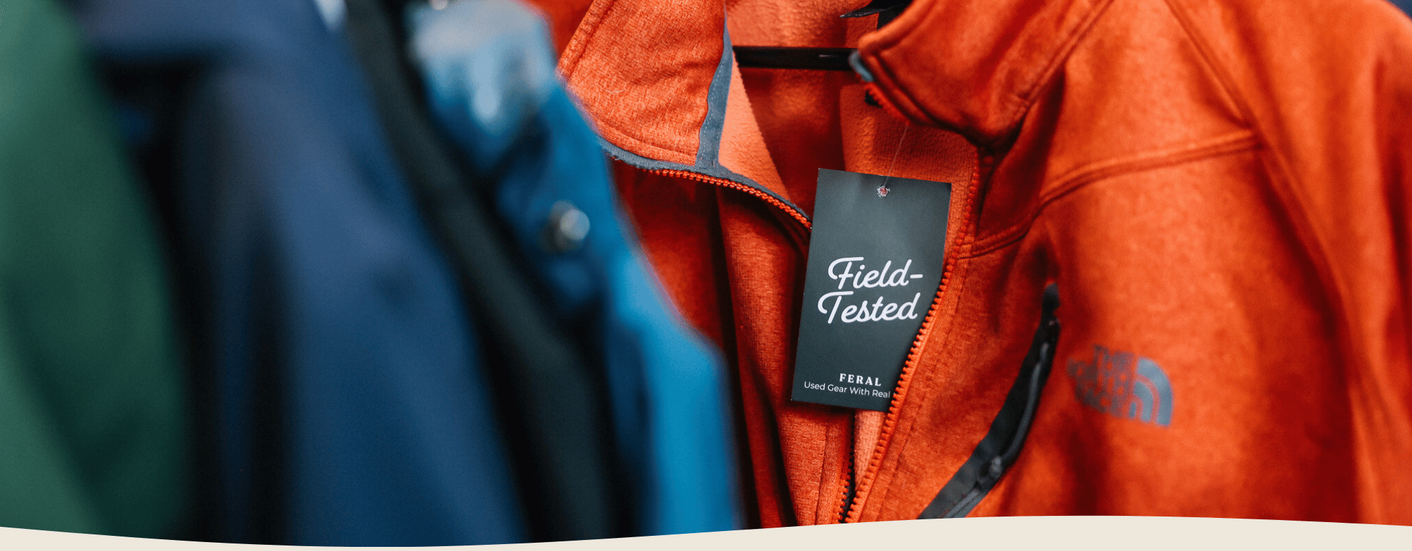 Orange jacket with a 'Field-Tested' tag on a blurred background