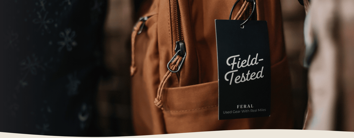 Dark tag on a brown backpack with cursive text that says 'Field-Tested'.