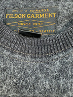 Grey wool sweater by Filson, with a textured, heathered knit and a brand tag visible at the neckline.