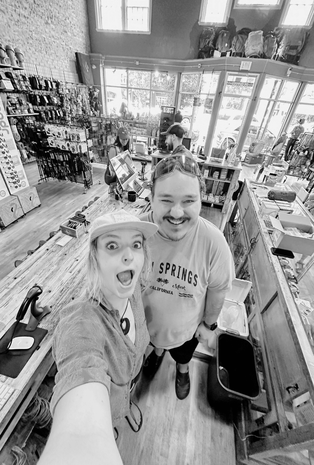 Two people taking a selfie in a store with shelves and products in the background