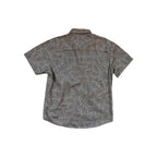 Tan short-sleeve shirt by Howler Bros, patterned with leaves, visible from the back.