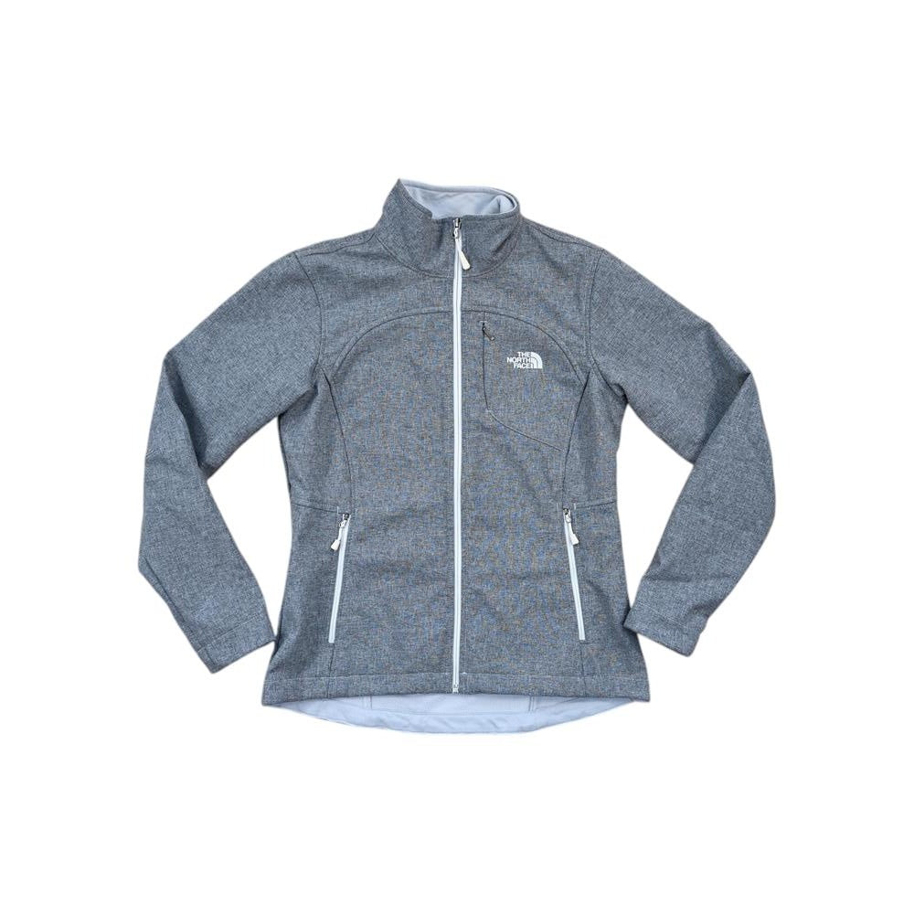 Gray softshell jacket by The North Face, with zippered pockets and a full zip front closure.