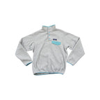 Gray fleece pullover by Patagonia with snap placket and blue trim on the collar, pocket, and hem.