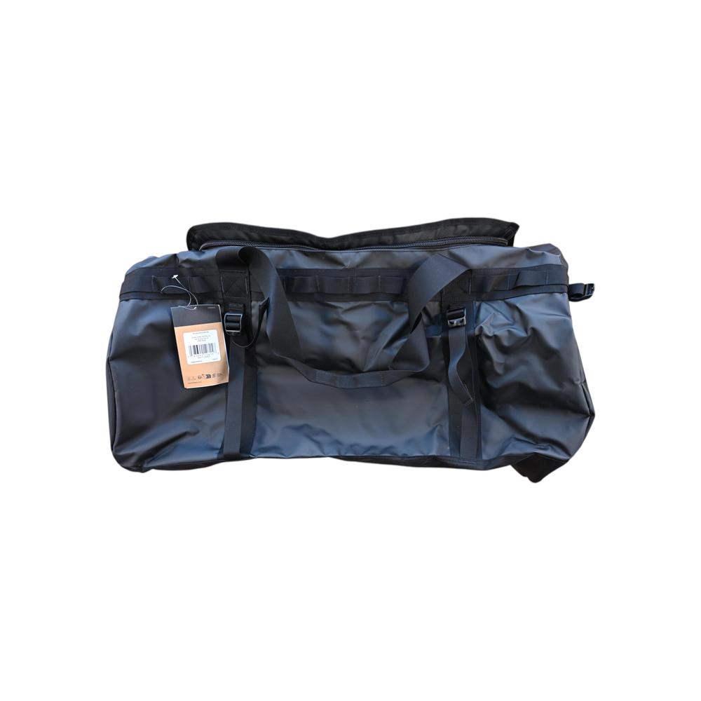 Black duffel bag by North Face with haul handles and several webbing straps.
