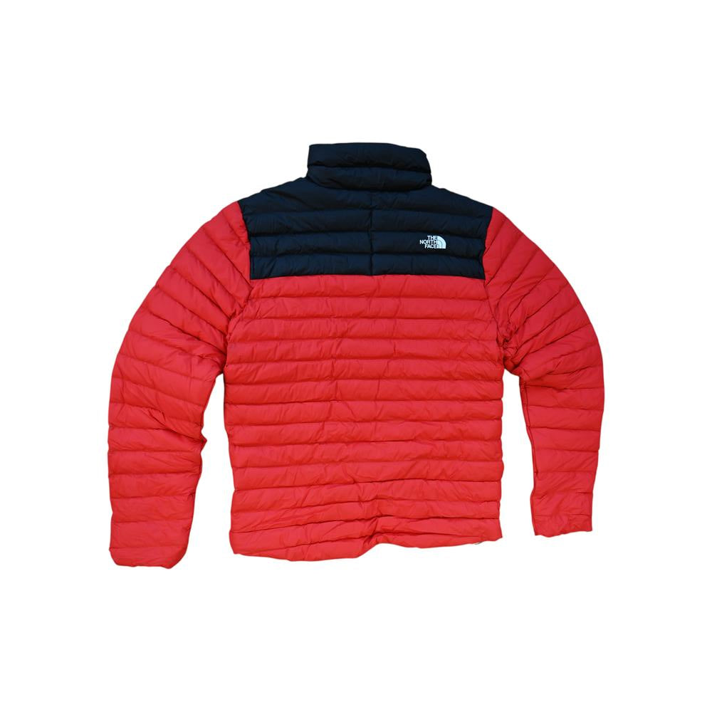 Red and black down jacket by The North Face with a quilted design and high collar.