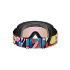 Ski goggles with a colorful geometric strap by Smith with black foam padding and pink mirrored lenses.